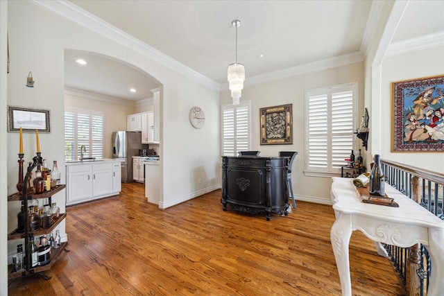 interior space featuring crown molding, sink, and hardwood / wood-style floors