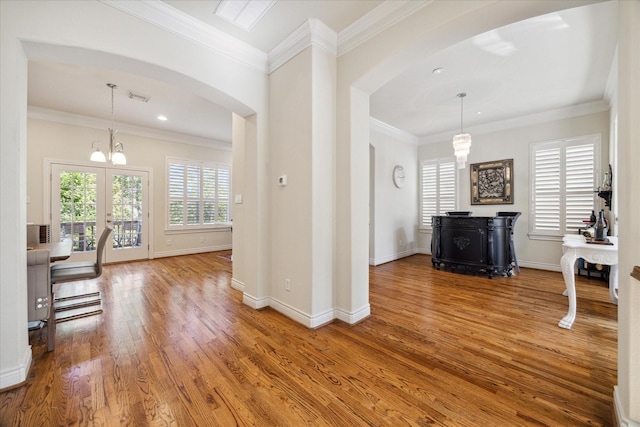 interior space with crown molding, hardwood / wood-style flooring, french doors, and an inviting chandelier