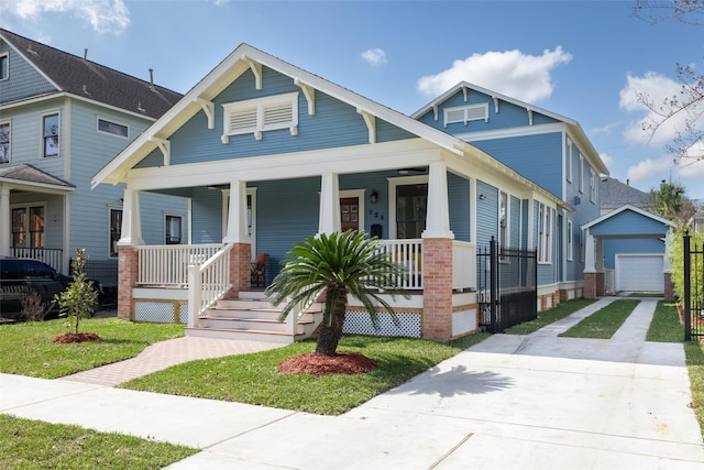 view of front of property featuring a garage, an outdoor structure, a front lawn, and covered porch