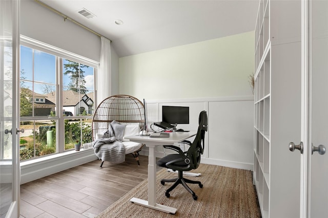 home office featuring hardwood / wood-style flooring, lofted ceiling, and a healthy amount of sunlight