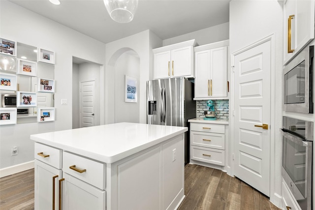 kitchen with white cabinetry, dark hardwood / wood-style floors, a center island, and appliances with stainless steel finishes