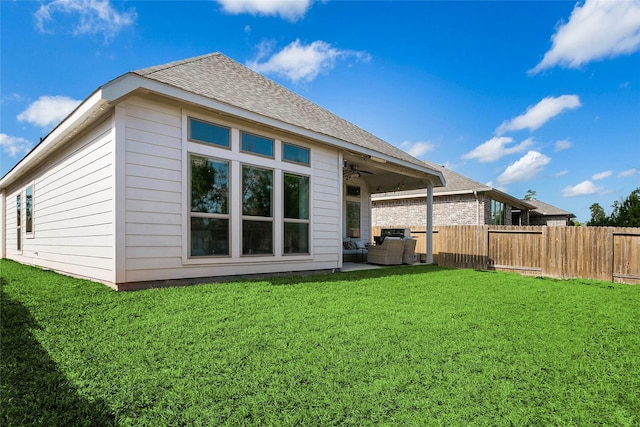 rear view of house with an outdoor living space, a lawn, ceiling fan, and a patio area