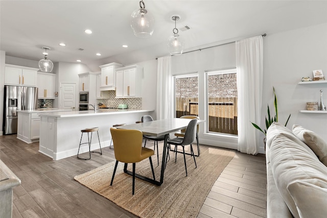 dining space with sink and light hardwood / wood-style flooring