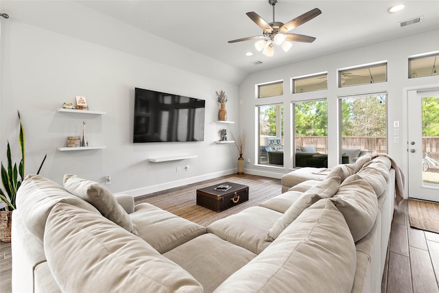 living room with lofted ceiling, hardwood / wood-style flooring, and ceiling fan