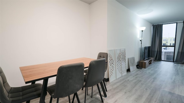 dining room featuring floor to ceiling windows and light wood-type flooring