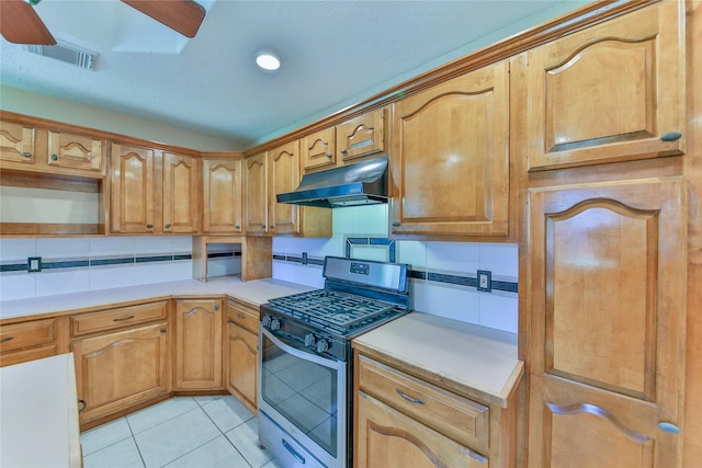 kitchen with light tile patterned floors, gas range, and backsplash