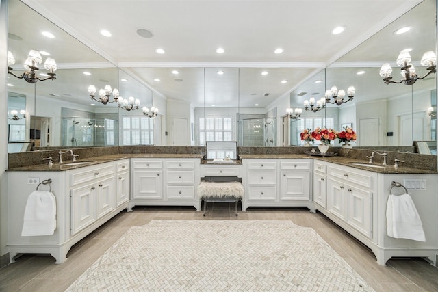 bathroom with ornamental molding, a chandelier, and walk in shower