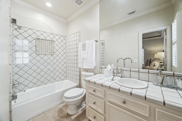 full bathroom featuring tiled shower / bath, vanity, crown molding, and toilet