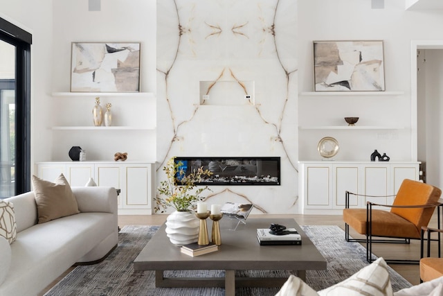 living room with wood finished floors and a high end fireplace