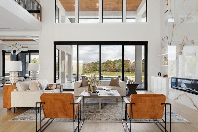 living area featuring a high ceiling, a premium fireplace, and wood finished floors