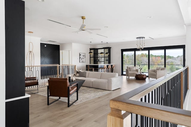 living area featuring light wood-style flooring, ornamental molding, a ceiling fan, and recessed lighting