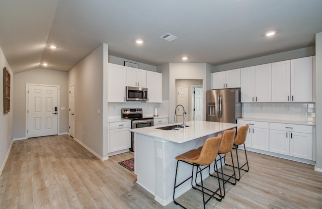 kitchen with a kitchen island with sink, sink, stainless steel appliances, and white cabinets