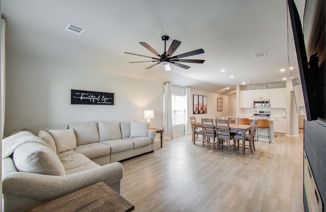 living room featuring ceiling fan and light hardwood / wood-style flooring