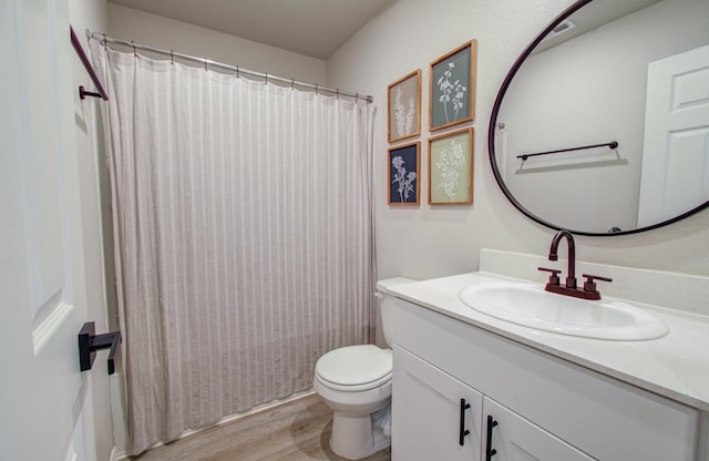 bathroom featuring vanity, hardwood / wood-style floors, a shower with shower curtain, and toilet