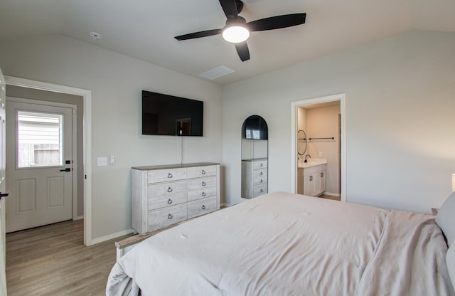 bedroom with vaulted ceiling, connected bathroom, ceiling fan, and light hardwood / wood-style floors