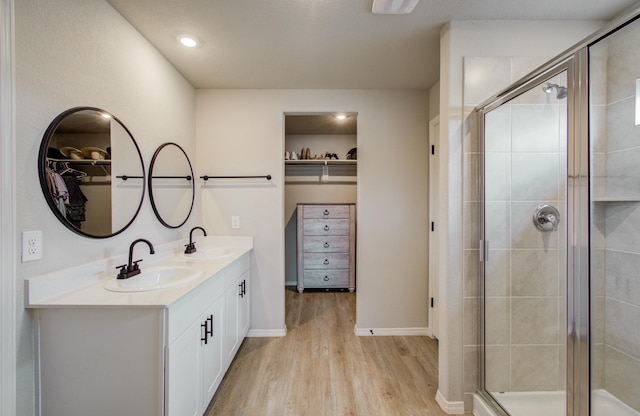 bathroom featuring walk in shower, vanity, and hardwood / wood-style floors