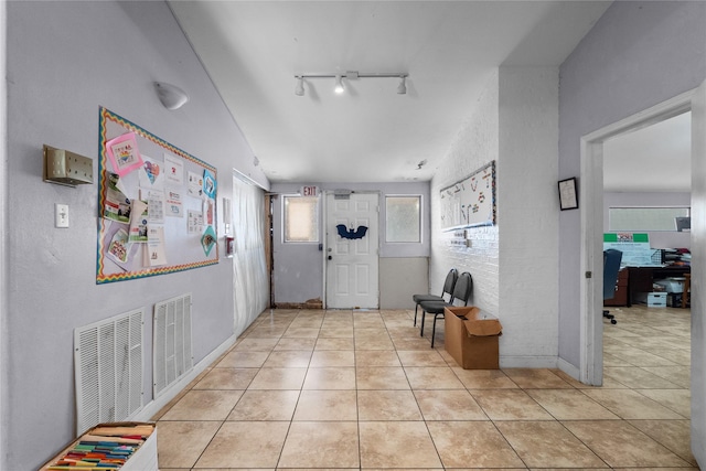 tiled entryway featuring track lighting