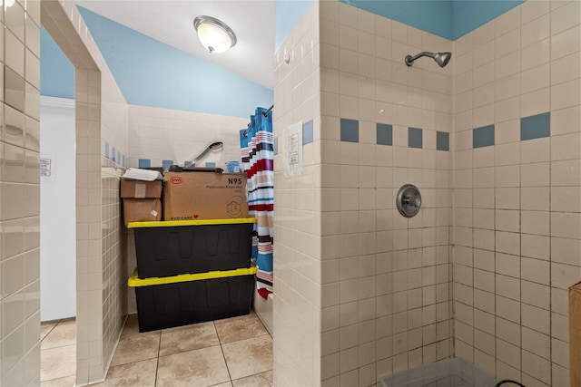 bathroom with tile walls, tile patterned floors, and a tile shower