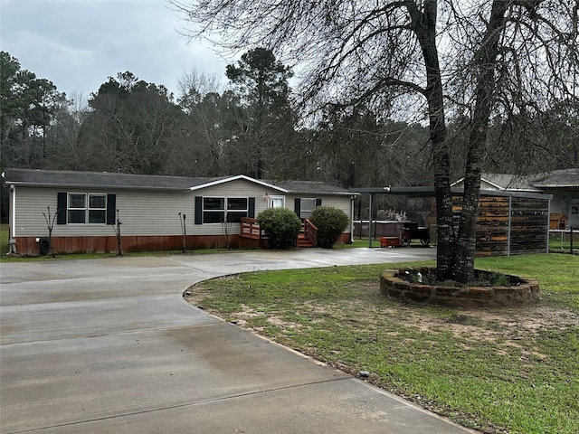 manufactured / mobile home featuring a carport and a front yard