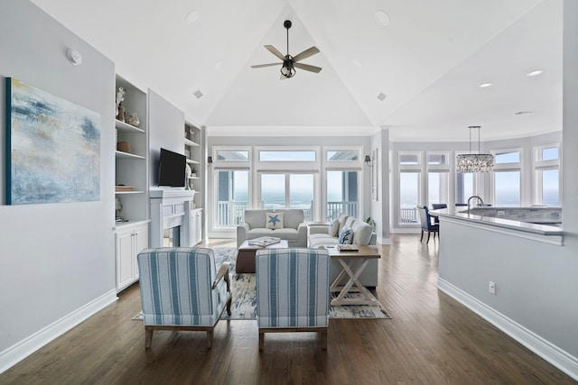 19307 Shores Dr, Galveston, TX 77554 - living room with built in shelves, high vaulted ceiling, dark hardwood / wood-style floors, and ceiling fan with notable chandelier