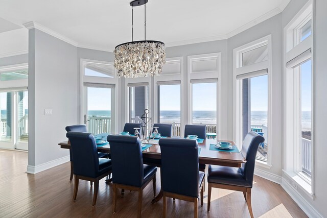 19307 Shores Dr, Galveston, TX 77554 - dining room featuring crown molding, wood-type flooring, a wealth of natural light, and a water view