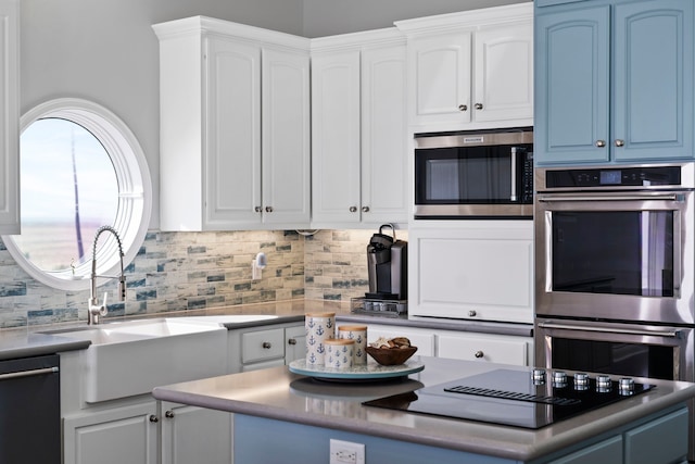 19307 Shores Dr, Galveston, TX 77554 - kitchen with sink, blue cabinetry, white cabinetry, tasteful backsplash, and black appliances