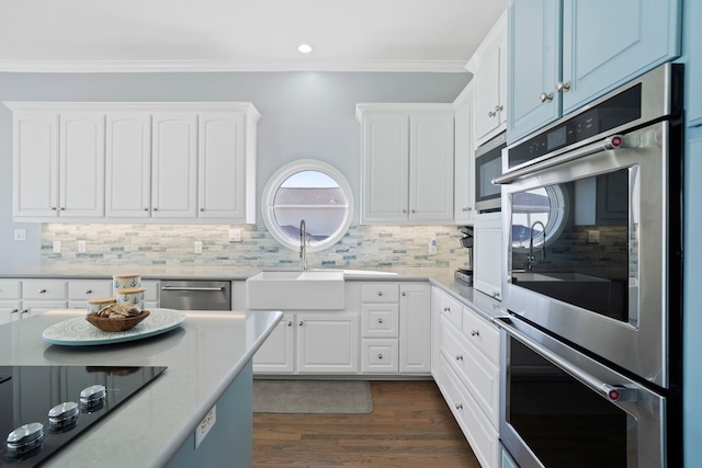 19307 Shores Dr, Galveston, TX 77554 - kitchen with sink, ornamental molding, appliances with stainless steel finishes, white cabinets, and backsplash