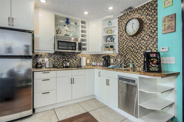 kitchen with sink, decorative backsplash, stainless steel appliances, and white cabinets