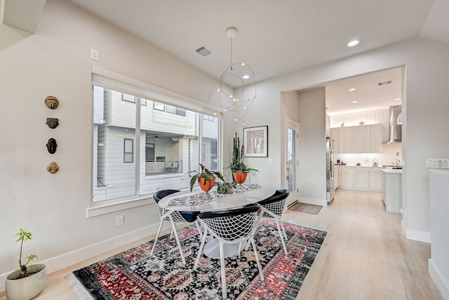 dining space featuring an inviting chandelier and light hardwood / wood-style floors