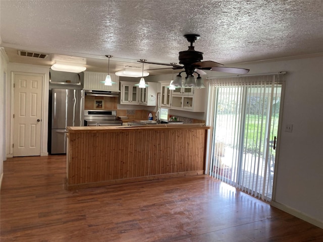 kitchen with stainless steel appliances, dark hardwood / wood-style flooring, kitchen peninsula, and hanging light fixtures