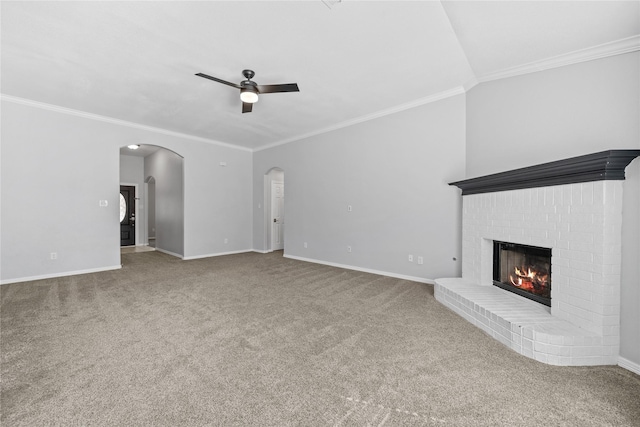 unfurnished living room featuring baseboards, arched walkways, a ceiling fan, carpet floors, and a fireplace