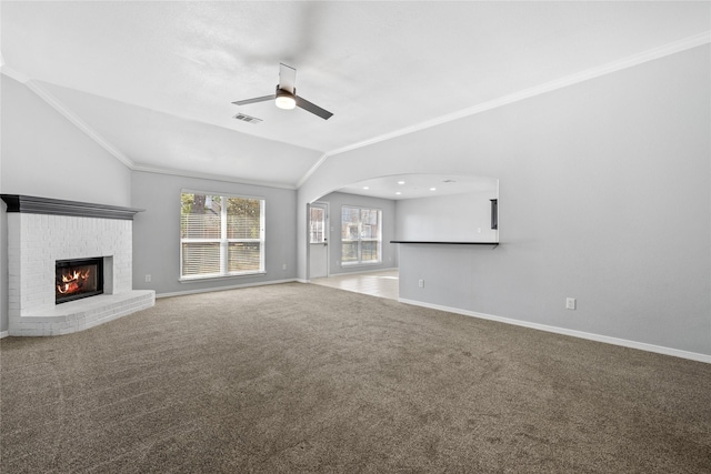 unfurnished living room featuring lofted ceiling, visible vents, ornamental molding, a brick fireplace, and carpet flooring