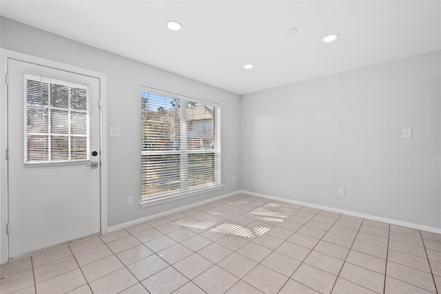 empty room with recessed lighting, baseboards, and light tile patterned floors