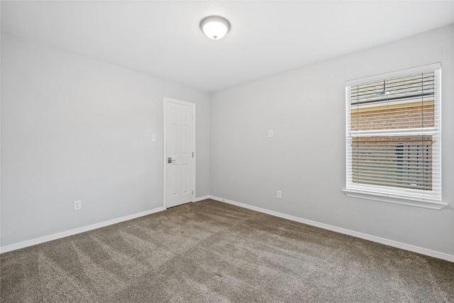 empty room featuring carpet floors and baseboards