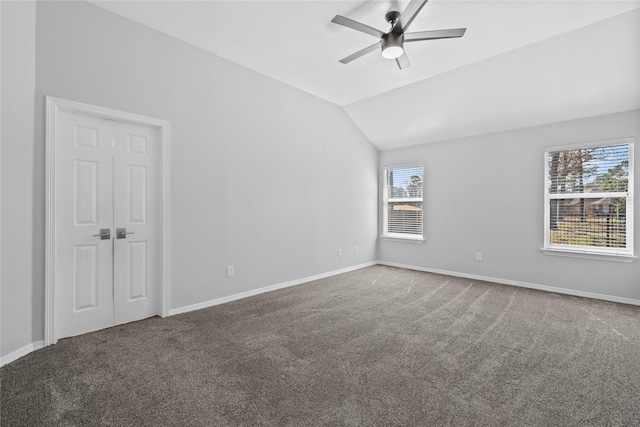 unfurnished room featuring carpet floors, baseboards, vaulted ceiling, and a ceiling fan