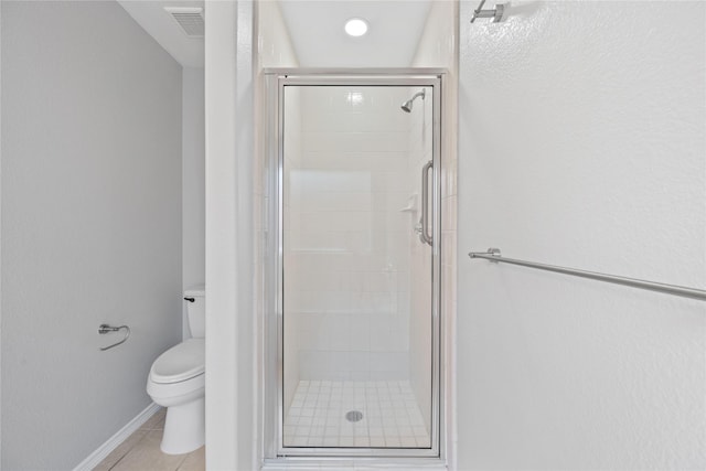 full bathroom featuring baseboards, a stall shower, toilet, and tile patterned floors