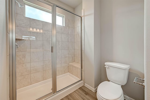 bathroom featuring hardwood / wood-style flooring, toilet, and walk in shower