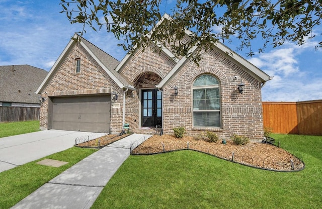 view of front of property featuring a garage, a front yard, and french doors