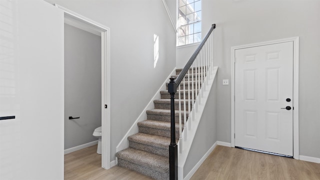 stairway featuring wood finished floors and baseboards