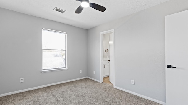 carpeted empty room featuring visible vents, ceiling fan, a textured ceiling, and baseboards