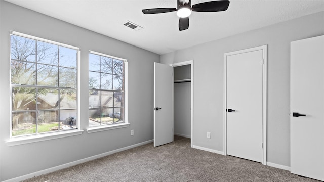 unfurnished bedroom with ceiling fan, carpet, visible vents, and baseboards