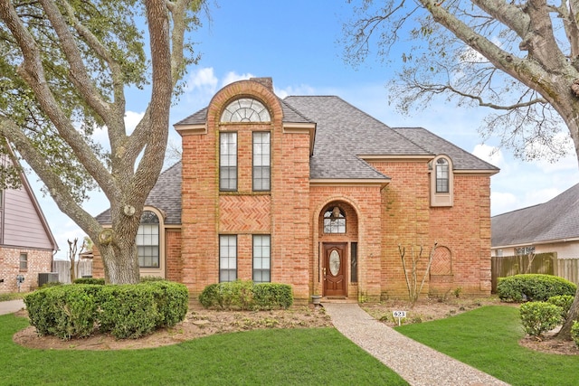 view of front of property with central AC unit and a front yard