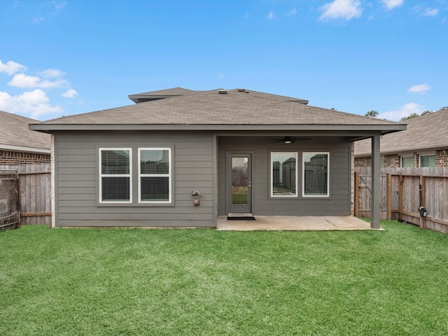 rear view of house with ceiling fan, a patio, and a lawn