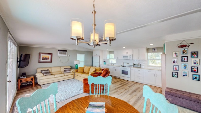 29331 County Rd 25, Damon, TX 77430 - interior space with an inviting chandelier, a wall mounted air conditioner, light hardwood / wood-style flooring, and vaulted ceiling