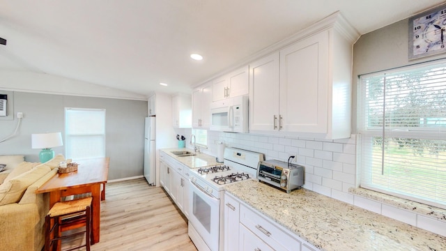29331 County Rd 25, Damon, TX 77430 - kitchen featuring white cabinetry, white appliances, lofted ceiling, and backsplash