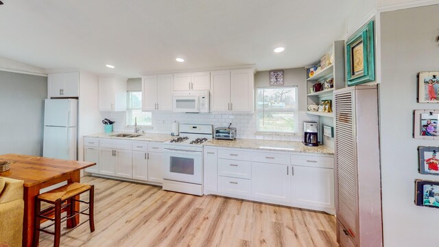 29331 County Rd 25, Damon, TX 77430 - kitchen featuring sink, white appliances, light stone countertops, white cabinets, and light wood-type flooring