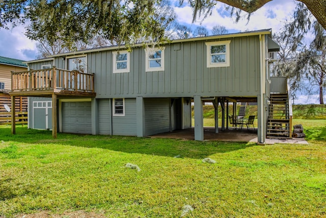 rear view of house featuring a garage, a wooden deck, and a yard