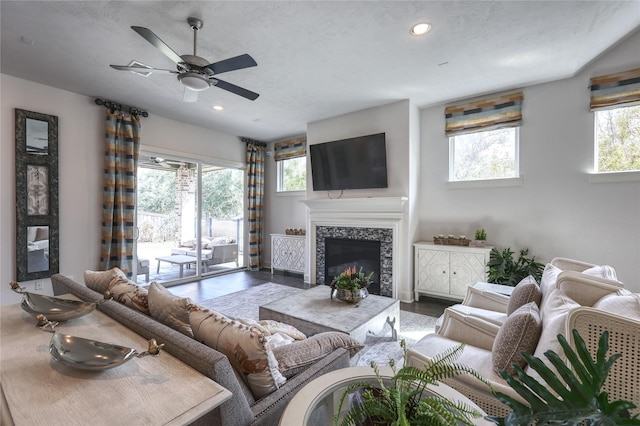 living room with ceiling fan and a textured ceiling