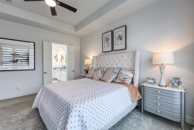 carpeted bedroom with a raised ceiling, ceiling fan, and ensuite bathroom