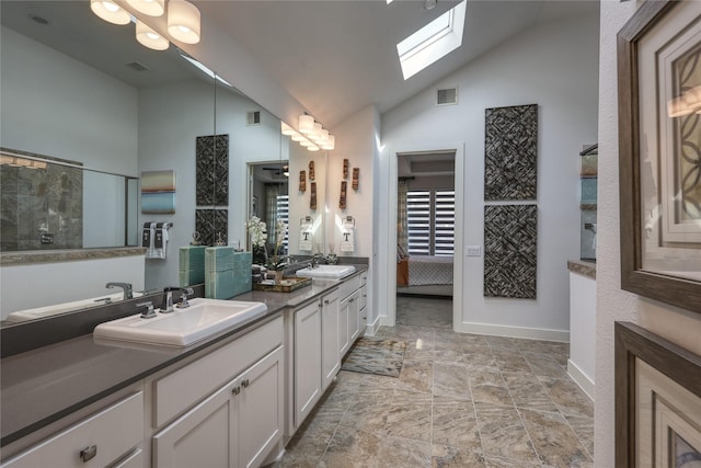 bathroom with vanity, high vaulted ceiling, and a skylight